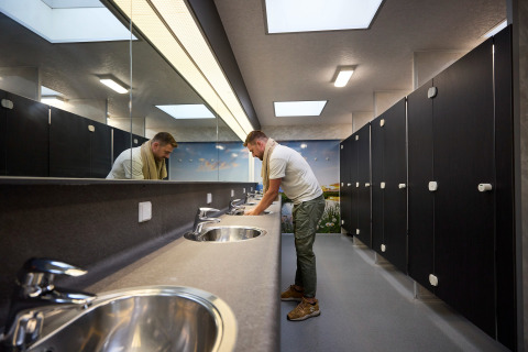 Mann wäscht sich die Hände im modernen Badezimmer im Ferienpark De Leistert in Limburg, Niederlande.