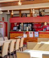 Helles Café mit Barbereich in einem Ferienpark mit Glamping-Unterkünften, moderne Einrichtung.