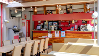 Helles Café mit Barbereich in einem Ferienpark mit Glamping-Unterkünften, moderne Einrichtung.