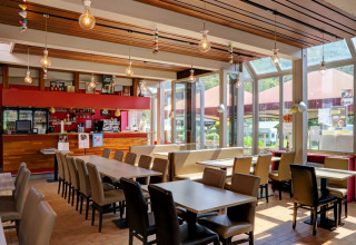 Zona pranzo luminosa e moderna in un villaggio vacanze, ideale per rilassarsi durante il glamping.