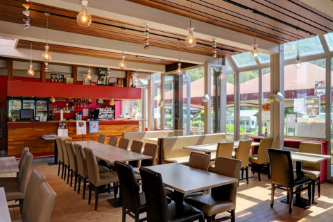 Zona pranzo luminosa e moderna in un villaggio vacanze, ideale per rilassarsi durante il glamping.