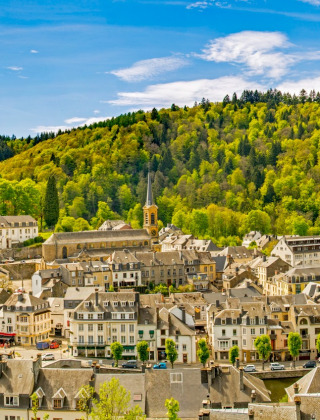 Panoramafoto eines Ferienparks mit Glamping-Unterkünften an einem Fluss, umgeben von Wäldern.