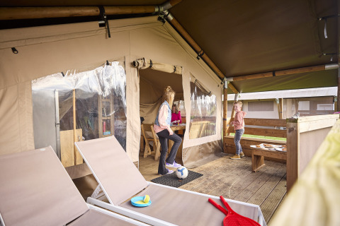 Kinderen spelen op het terras van een Kalahari safaritent bij De Leistert in Nederland, gezellig en ruim.