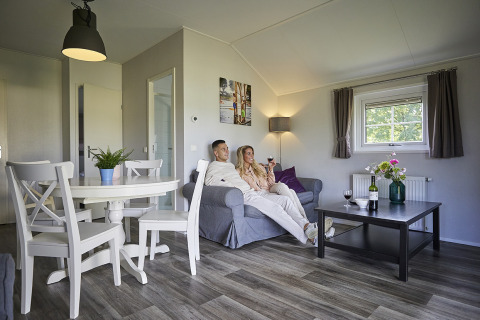 Paar genießt Wein im Wohnzimmer der Leistert Lodge in De Leistert, Niederlande, modern eingerichtet