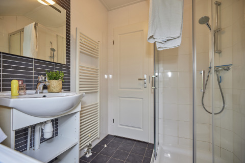 Modernes Badezimmer in der Leistert Lodge, De Leistert, Niederlande mit Dusche, Waschbecken und Handtüchern.