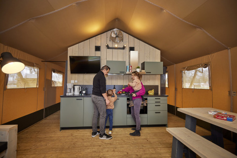 Familie verbringt gemeinsame Zeit in einer modernen Safari-Glampingzelt-Küche im De Leistert, Niederlande.
