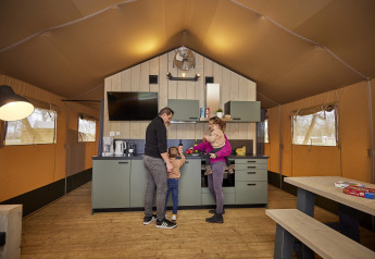 Famiglia che trascorre del tempo insieme nella cucina di una tenda glamping di lusso a De Leistert, Paesi Bassi.