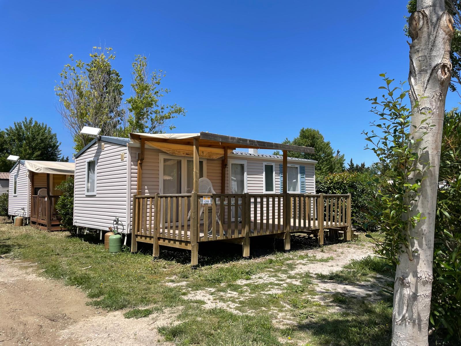 Foto van een huisje met airconditioning op Camping Seasonova Ensoya in Frankrijk onder een blauwe lucht.