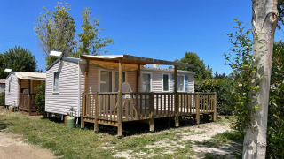 Photo d’un cottage climatisé au Camping Seasonova Ensoya en France sous un ciel bleu et ensoleillé.