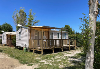 Photo d’un cottage climatisé au Camping Seasonova Ensoya en France sous un ciel bleu et ensoleillé.
