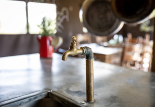 Vieux robinet en laiton dans une tente safari à Glampinglodge de luxe avec salle de bain privée, Domaine Bonneblond, France.
