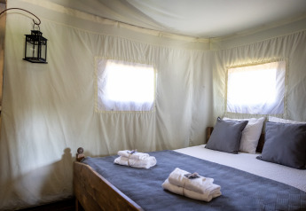 Tienda safari Glampinglodge de luxe con baño privado en Domaine Bonneblond, Francia, interior acogedor y cama.