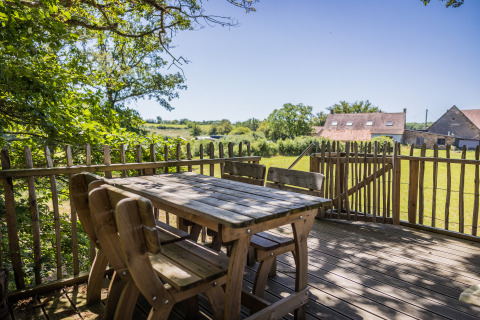 Holzterrasse des Baumhauses Boomhuis im Domaine Bonneblond, Frankreich, mit ländlicher Aussicht.