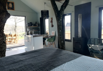 Indvendig udsigt af Boomhuis træhus med synlige træstammer og moderne indretning på Domaine Bonneblond i Frankrig.