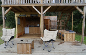 Outdoor lounge area at the Papillon safari tent in Domaine Bonneblond, France, featuring wooden furniture.