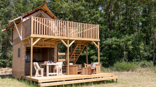 Safaritent Papillon bij Domaine Bonneblond in Frankrijk, met houten terras en omgeven door bos.