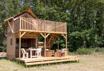 Tienda safari Papillon en Domaine Bonneblond, Francia, con terraza de madera y rodeada de bosque.