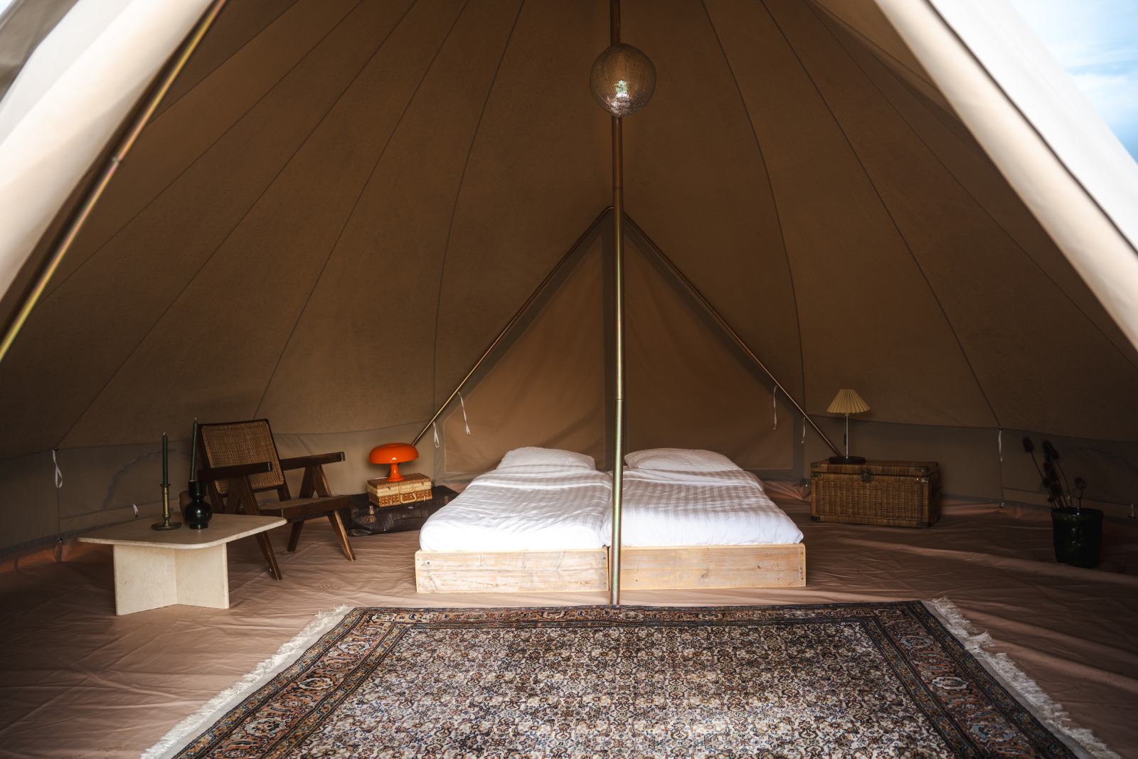 Interieur van een Bell tent op Domaine Bonneblond in Frankrijk met twee bedden en een vloerkleed.