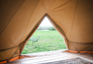 Zicht vanuit een tipi tent op het veld bij de Bell tents op Domaine Bonneblond, Frankrijk.