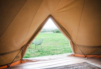 Zicht vanuit een tipi tent op het veld bij de Bell tents op Domaine Bonneblond, Frankrijk.