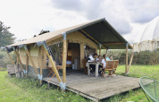 Famille réunie devant une tente safari avec sanitaires privés au Domaine Bonneblond, France, au cœur de la nature.