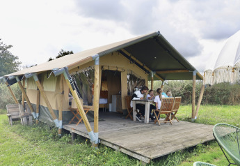 Famille réunie devant une tente safari avec sanitaires privés au Domaine Bonneblond, France, au cœur de la nature.
