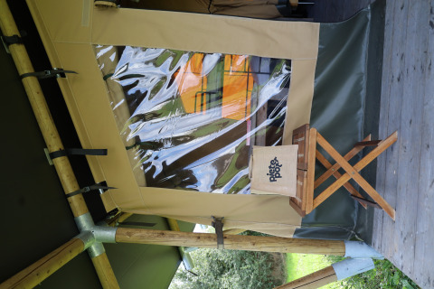 Safari tent with private sanitary facilities at Domaine Bonneblond in France, wooden stool outside.