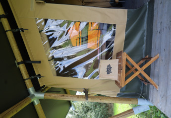 Safari tent with private sanitary facilities at Domaine Bonneblond in France, wooden stool outside.