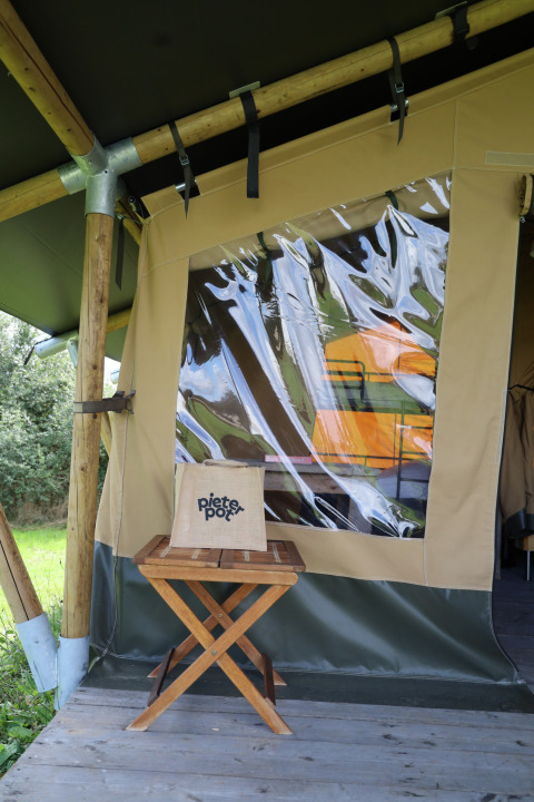 Safari tent with private sanitary facilities at Domaine Bonneblond in France, wooden stool outside.