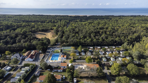 Vista aérea de Flower Camping La Davière Plage en Pays de la Loire, Francia, con piscina, casas móviles y bosque.