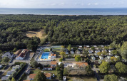 Luftfoto af Flower Camping La Davière Plage i Pays de la Loire, Frankrig, med skov, swimmingpool og kystlinje.