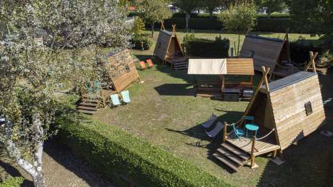 Vista aérea de cabañas de madera y área de descanso en Flower Camping La Davière Plage, Pays de la Loire.