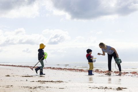Una mujer y dos niños juegan en la playa de Flower Camping La Davière Plage en Pays de la Loire, Francia.