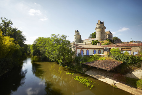 Castle by a river with lush greenery near Saint Jean de Monts in the Pays de la Loire region, France.