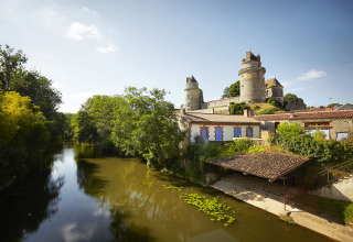 Castle by a river with lush greenery near Saint Jean de Monts in the Pays de la Loire region, France.