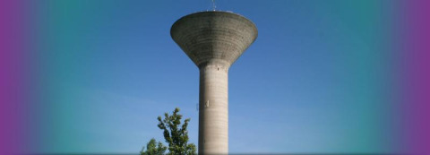 Water tower stands against clear blue sky at Flower Camping La Davière Plage, Pays de la Loire, France.