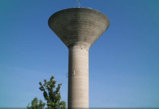 Water tower stands against clear blue sky at Flower Camping La Davière Plage, Pays de la Loire, France.