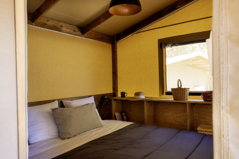 Vista interior de la cómoda Hut Cotton Confort, tienda safari en Flower Camping La Davière Plage, Francia.