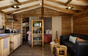 Interieur van het CosyFlower Confort safaritent met houten inrichting bij Flower Camping La Davière Plage, Frankrijk.