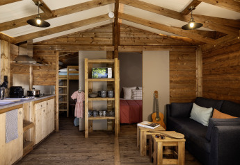 Binnenzicht van de CosyFlower Confort safaritent met houten interieur bij Flower Camping La Davière Plage, Frankrijk.