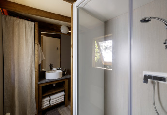 Bagno nella tenda safari CosyFlower Confort a Flower Camping La Davière Plage, Francia, con doccia e lavandino.