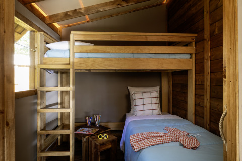 Interno di una tenda safari al CosyFlower Confort, Flower Camping La Davière Plage, con letto a castello.