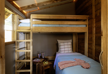 Binnenkant van een safaritent in CosyFlower Confort, Flower Camping La Davière Plage, met stapelbed.