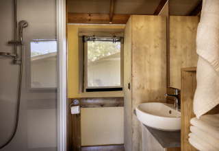 Moderne badkamer in safaritent Hut Cotton Confort bij Flower Camping La Davière Plage, Frankrijk.