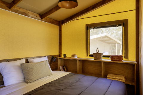 Indretning af soveområde i en safarihytte hos Hut Cotton Confort, Flower Camping La Davière Plage, Frankrig.