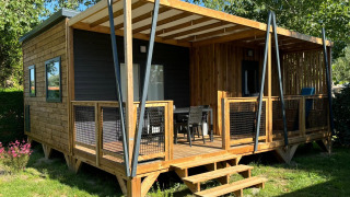 Foto del chalet Cottage Cannelle con exterior de madera y amplia terraza en un entorno verde y natural.