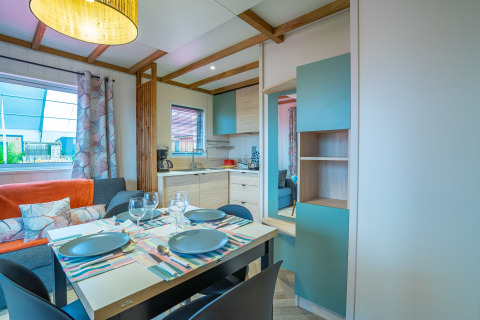 Moderna zona pranzo e soggiorno all'interno del Cottage Cannelle al Flower Camping La Davière Plage in Francia.