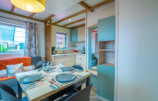 Moderne eet- en woonkamer in Cottage Cannelle op Flower Camping La Davière Plage in Frankrijk.
