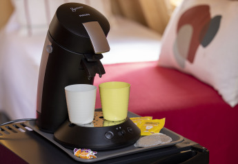 Macchina da caffè con due tazze e accessori su un tavolo in una cabina a Flower Camping La Davière Plage in Francia.