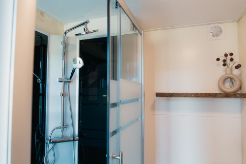 Moderne douche en stijlvolle plank met vaas in Big Lodge bij Holiday park De Boshoek, Nederland.